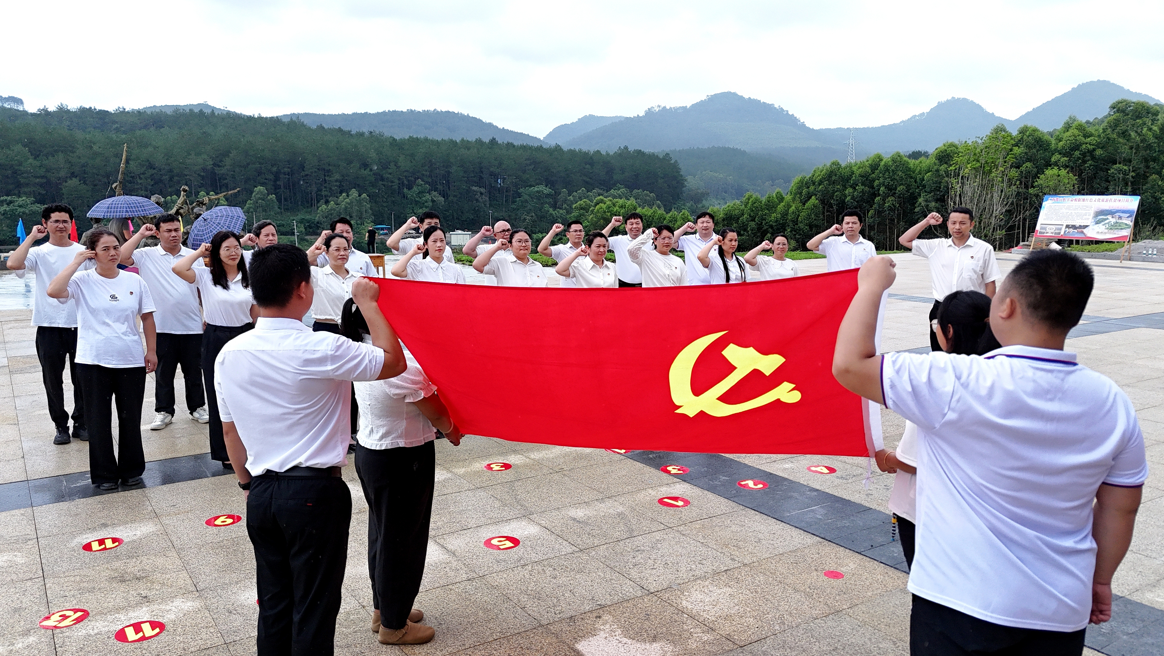 2025年7月1日,广西都宜忻人民解放总队纪念馆前,党员面向党旗重温入党誓词。