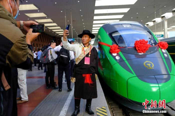 2021年6月25日，川藏铁路拉林段(拉林铁路)正式开通运营，复兴号高原内电双源动车组同步投入运营。拉林铁路全长48公里，设计时速160公里。这是西藏首条电气化铁路，也是复兴号动车组首次开进西藏。图为当日，民众在拉萨火车站复兴号车头前拍照留念。 <a target='_blank' href='/'>中新社</a>记者 江飞波 摄
